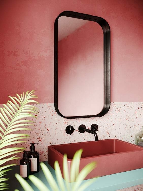 rausvas šiuolaikiškas vonios kambarys su veidrodžiu su juodu rėmeliu ir juodu čiaupu